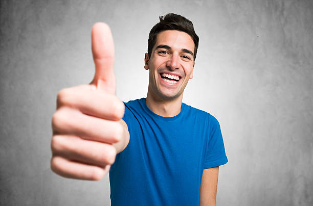 portrait of a young man giving thumbs up